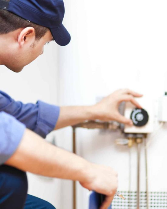 Smiling technician repairing an hot-water heater